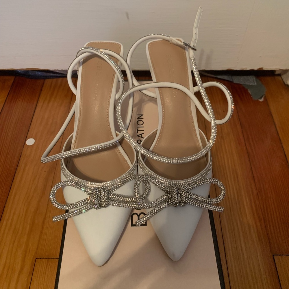 A pair of white BCBG, 1 inch heels.